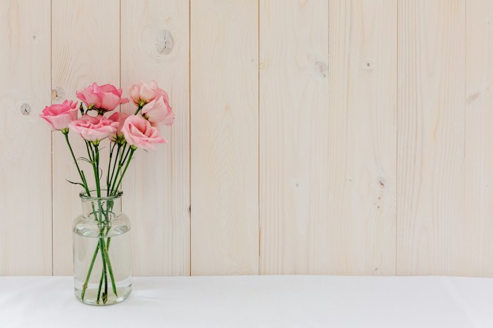 Arreglo floral en florero de vidrio con flores rosas